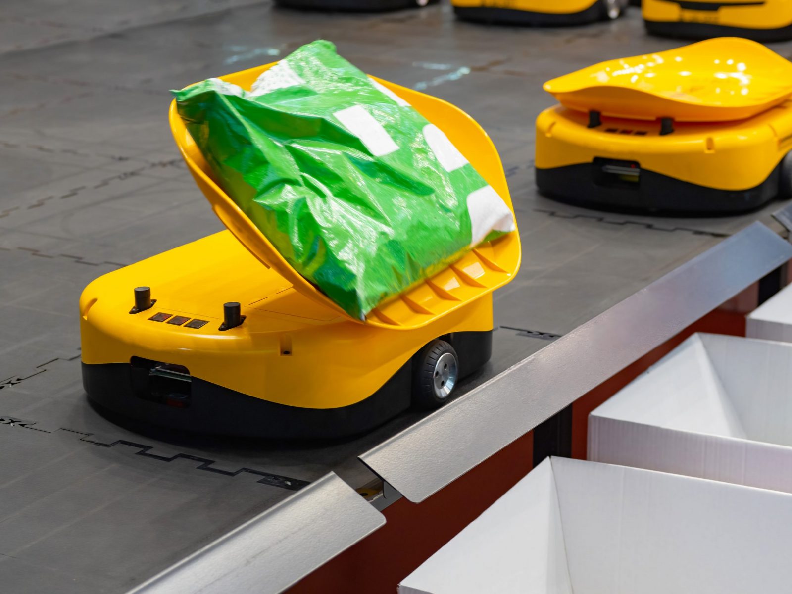 warehouse-robot-sorter-miniature-yellow-robot-for-moving-goods-to-storage-location-warehouse-robot-with-green-package-automated-warehouse-sorter-innovative-technologies-in-storage-industry