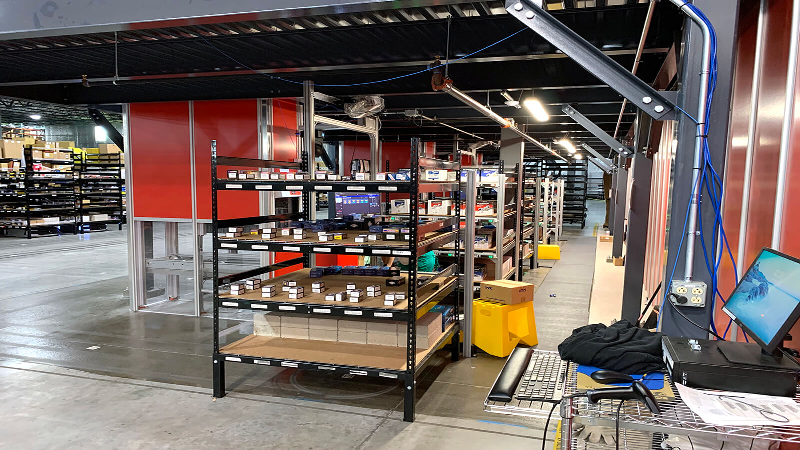 AutoStore grid with workstation and shelving in warehouse