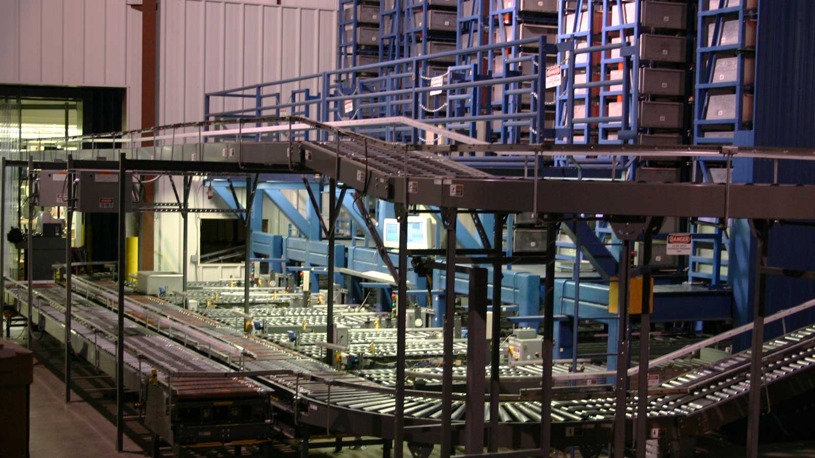 Automated conveyor and storage system with sorting bins in facility.