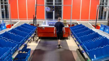 Warehouse worker in goods to person pick area of AutoStore system