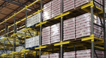Spacious beverage co-packer and distributor warehouse showcasing multiple levels of Twinlode Dual-Wide Pallet Racking. Stacked pallets, organized in neat rows, hold boxes of beverages.