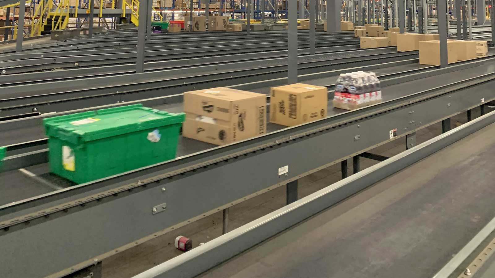 Totes and cases moving along a belt conveyor